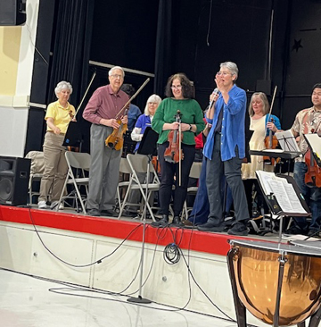 conductor and some of the strings taking a bow
